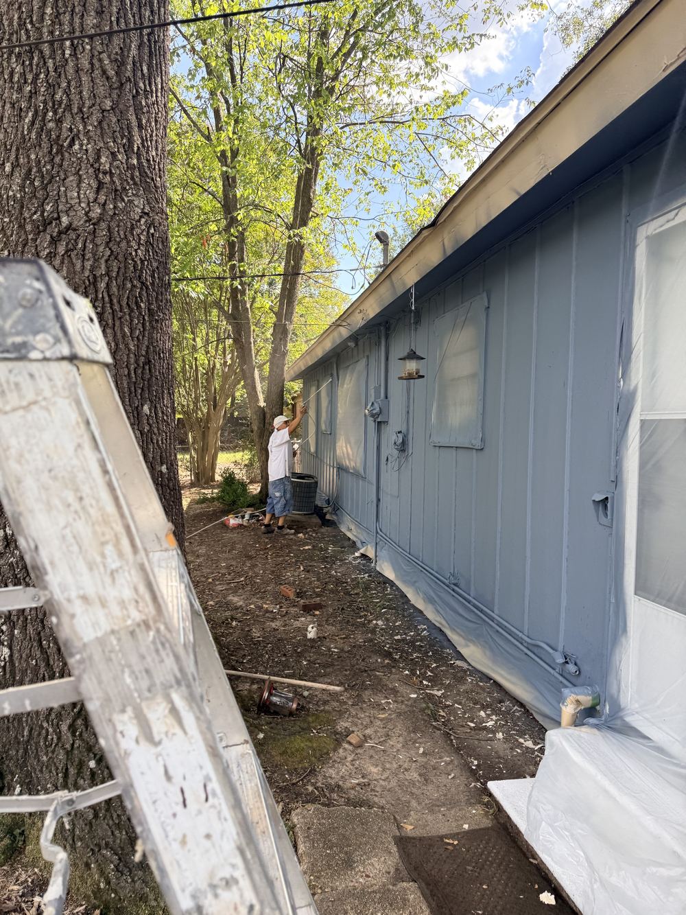 Lumin8 Painting crew member painting exterior siding in Texarkana TX