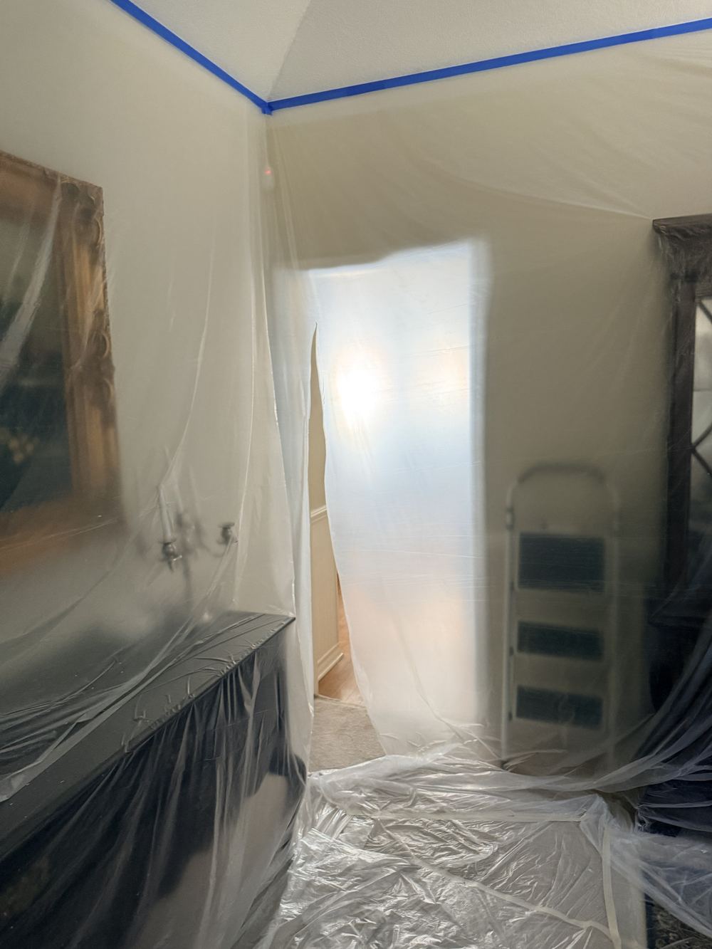 Interior room fully masked in plastic sheeting before painting
